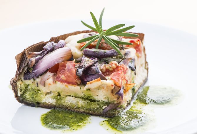 Focaccia de fermentação natural com tomate, cebola roxa, alecrim e pesto genovese (R$ 32 o quilo). Foto: Letícia Akemi/Gazeta do Povo. Focaccia de fermentação natural com tomate, cebola roxa, alecrim e pesto genovese (R$ 32 o quilo). Foto: Letícia Akemi/Gazeta do Povo.