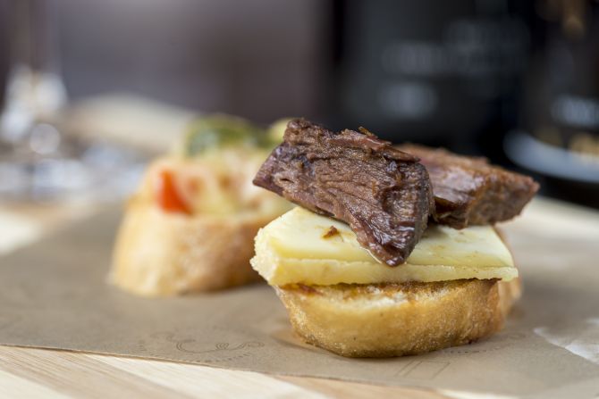 Para acompanhar os vinhos, tem bruschettas como essa com queijo da Serra do Salitre e carne de panela (R$ 4). Foto: Fernando Zequinão/Gazeta do Povo. Para acompanhar os vinhos, tem bruschettas como essa com queijo da Serra do Salitre e carne de panela (R$ 4). Foto: Fernando Zequinão/Gazeta do Povo.