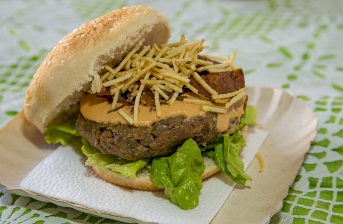 "O-grão", sanduíche feito pela Fejón Cozinha Vegana que combina hambúrguer de lentilha, linguiça de glúten, batata palha e mais ingredientes veganos. Foto: Hugo Harada/Gazeta do Povo "O-grão", sanduíche feito pela Fejón Cozinha Vegana que combina hambúrguer de lentilha, linguiça de glúten, batata palha e mais ingredientes veganos. Foto: Hugo Harada/Gazeta do Povo