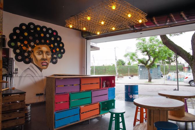 Com graffiti do artista Café e decoração com itens reaproveitados, o Barateza Bar fica de frente para a pista de skate da Praça do Gaúcho. Foto: Juan Azevedo/Divulgação Com graffiti do artista Café e decoração com itens reaproveitados, o Barateza Bar fica de frente para a pista de skate da Praça do Gaúcho. Foto: Juan Azevedo/Divulgação