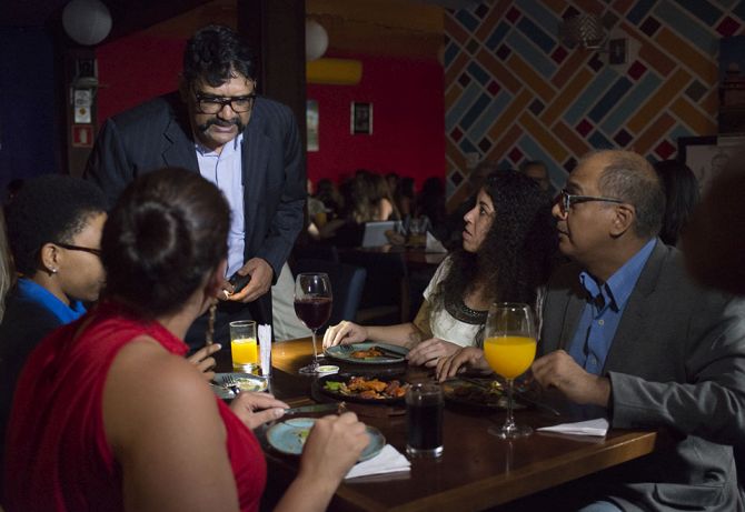 O proprietário Vijay Baraska atende uma mesa com o restaurante às escuras. Foto: Carlos Reinis/Divulgação O proprietário Vijay Baraska atende uma mesa com o restaurante às escuras. Foto: Carlos Reinis/Divulgação