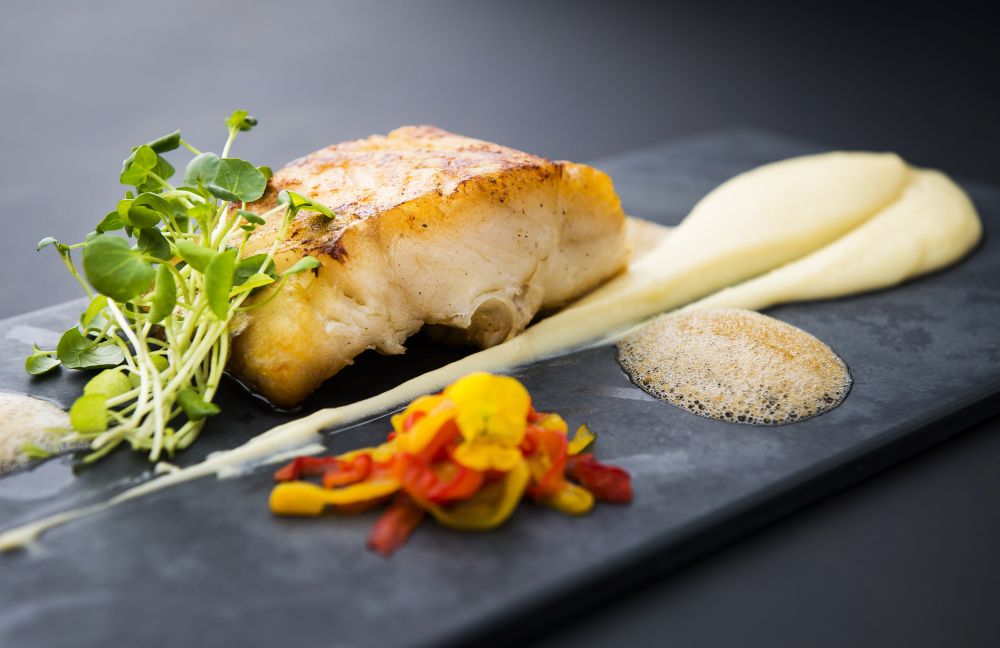 Lombo de bacalhau assado é servido com purê de batata e alho, confit de pimentão e espuma de azeitona preta (R$ 79). (Foto: Letícia Akemi/Gazeta do Povo) Lombo de bacalhau assado é servido com purê de batata e alho, confit de pimentão e espuma de azeitona preta (R$ 79). (Foto: Letícia Akemi/Gazeta do Povo)