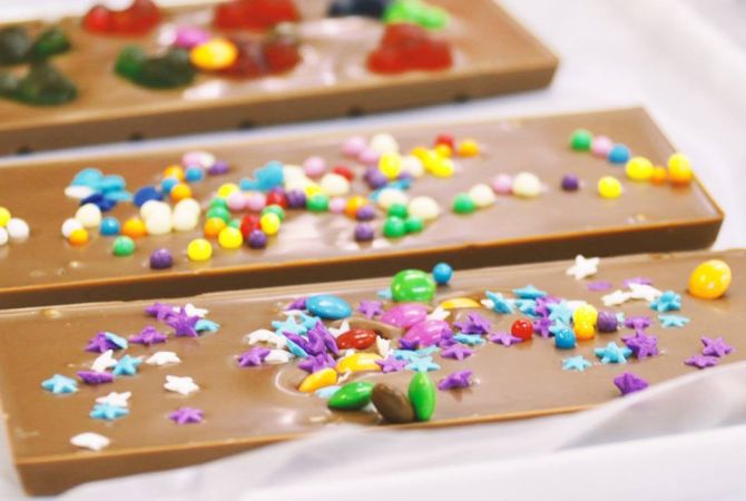 Na oficina de chocolate da Cuore di Cacao, as crianças preparam três barrinhas de chocolate com a chef chocolatière Carolina Schneider. Foto: Divulgação Na oficina de chocolate da Cuore di Cacao, as crianças preparam três barrinhas de chocolate com a chef chocolatière Carolina Schneider. Foto: Divulgação