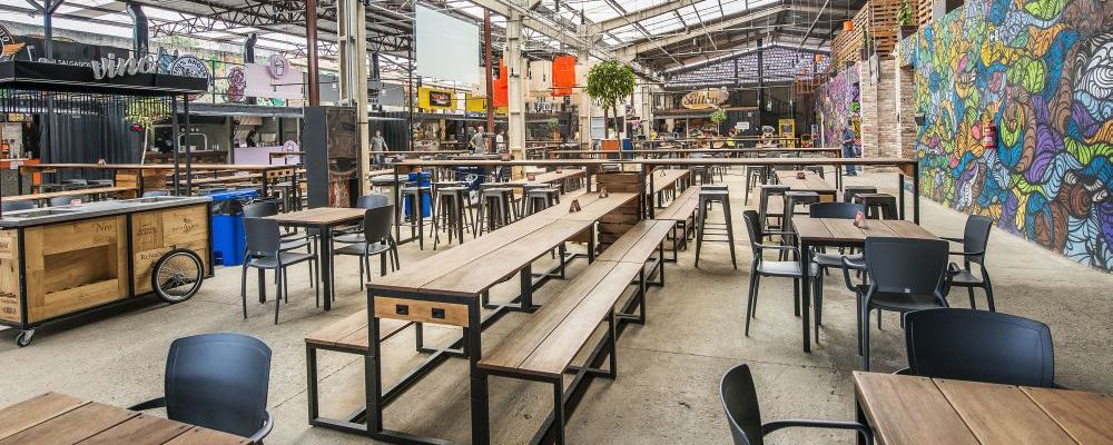 Área interna do Mercado Sal com mesas e algumas operações gastronômicas. (Foto: Letícia Akemi/Gazeta do Povo)