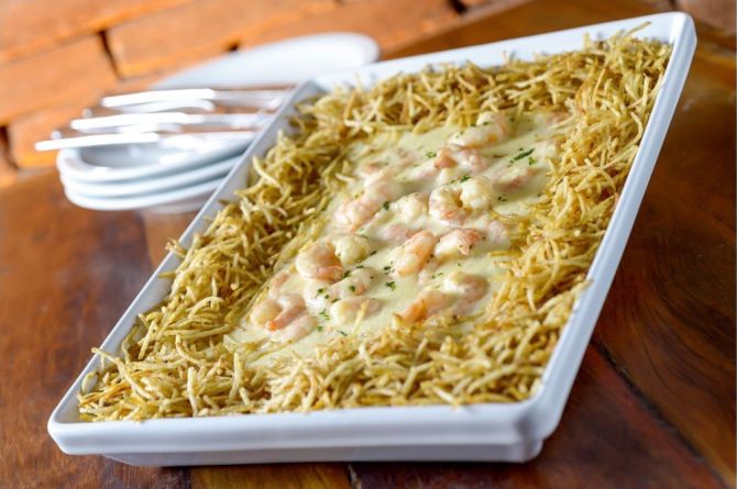 O Camarão Internacional é servido sobre arroz cremoso com ervilhas e presunto, envolvido com molho branco e gratinado. É o prato com camarão mais vendido no restaurante. Foto: Divulgação O Camarão Internacional é servido sobre arroz cremoso com ervilhas e presunto, envolvido com molho branco e gratinado. É o prato com camarão mais vendido no restaurante. Foto: Divulgação