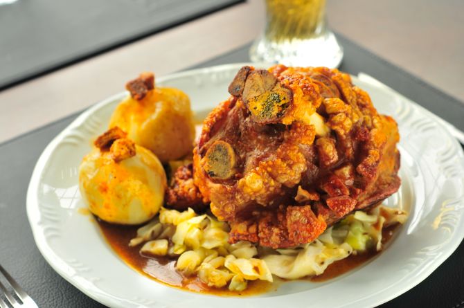 O joelho de porco (Schweishaxen) é servido pururucado guarnecido com bolinhos de batata, chucrute, repolho roxo e salsichas Bratwurst. Valor R$ 97,90 (para 2 pessoas). Foto: Divulgação O joelho de porco (Schweishaxen) é servido pururucado guarnecido com bolinhos de batata, chucrute, repolho roxo e salsichas Bratwurst. Valor R$ 97,90 (para 2 pessoas). Foto: Divulgação