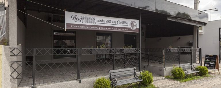 Fachada do NY Café no Alto da XV com uma faixa avisando que a cafeteria continua funcionando no Batel. Foto: Fernando Zequinão/Gazeta do Povo