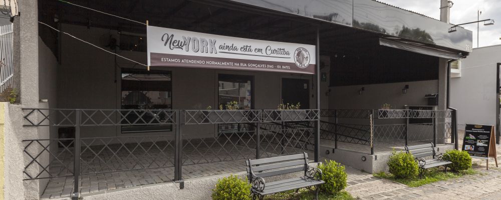 Fachada do NY Café no Alto da XV com uma faixa avisando que a cafeteria continua funcionando no Batel. Foto: Fernando Zequinão/Gazeta do Povo