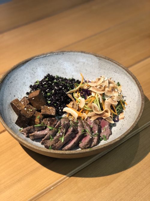 Baby beef grelhado acompanhado de um arroz negro, legumes picados, gengibre, chips de coco e um molho tailandês, servido no Green Up. Foto: João Santos Baby beef grelhado acompanhado de um arroz negro, legumes picados, gengibre, chips de coco e um molho tailandês, servido no Green Up. Foto: João Santos