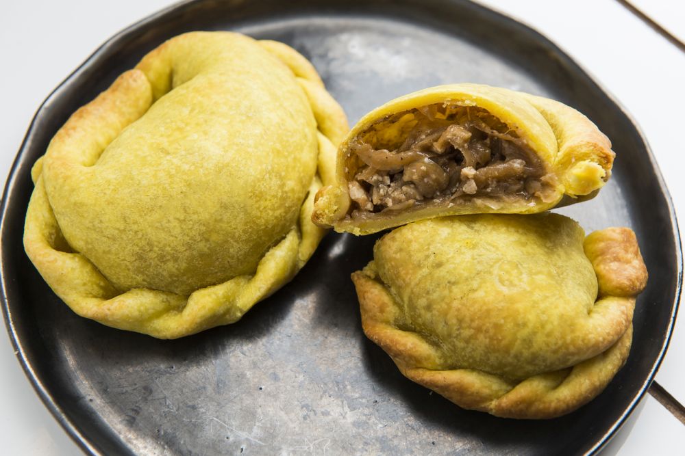 A empanada com recheio de cebola caramelizada foi "importada" de Barcelona e é o carro-chefe do Gracias. Foto: Letícia Akemi/Gazeta do Povo. A empanada com recheio de cebola caramelizada foi "importada" de Barcelona e é o carro-chefe do Gracias. Foto: Letícia Akemi/Gazeta do Povo.