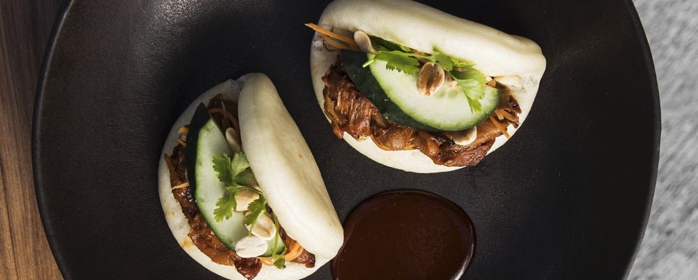 Bao (pão cozido no vapor) recheado de jaca braseada, pimenta gochujang e milho, com amendoim e pepino japonês fresco. Foto: Divulgação/SACRO