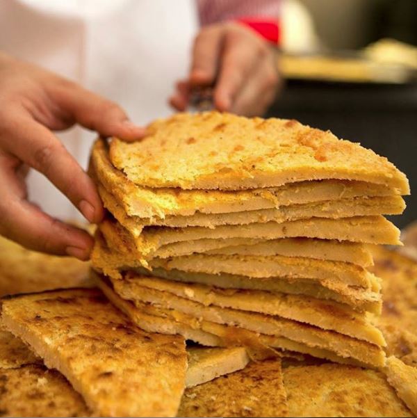 Fainá, massa de grão de bico. Foto: Divulgação/Pizzaria Güerrin. Fainá, massa de grão de bico. Foto: Divulgação/Pizzaria Güerrin.