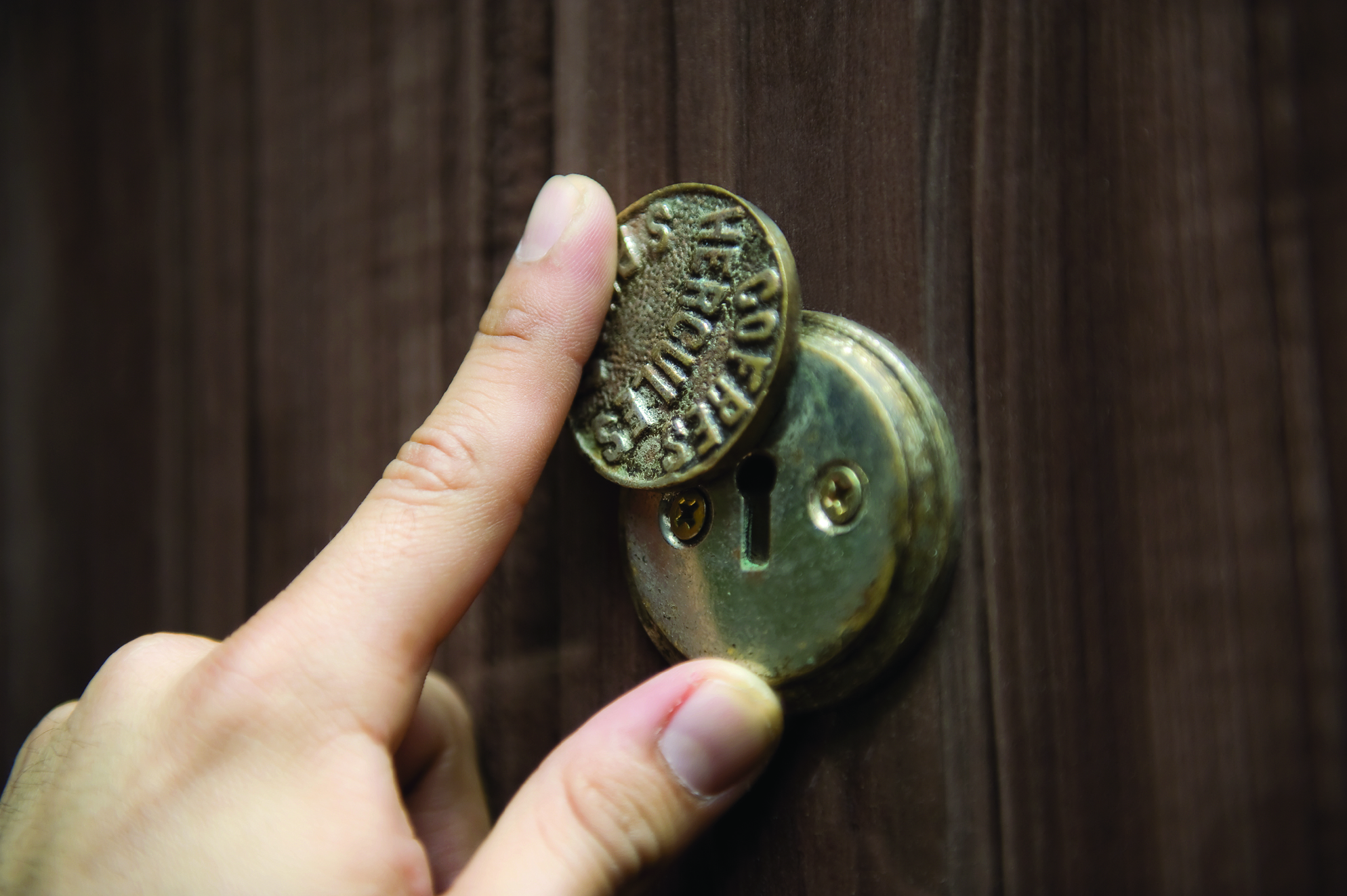 O visitante visualiza as fotos da mostra de Key Imaguire Junior através de fechaduras, aguçando a curiosidade.