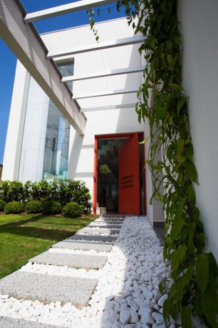 Caminhos de jardim que vão muito além da função de ir e vir O projeto assinado por Valliatti e Patrão tem piso de cerâmica que imita concreto aparente, dando um toque rústico ao décor. Foto: Daniela Buzzi/Divulgação.