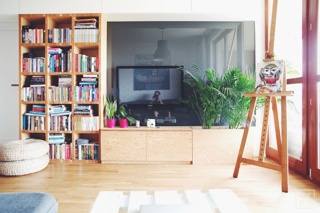 Apartamento de 51 m² em Varsóvia ganha espaço com móveis em marcenaria Na sala, sensação de continuidade entre os elementos e a inserção do verde. Foto: Divulgação/OFDA