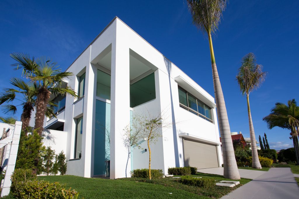 Paisagismo tropical e estilo contemporâneo são as marcas fortes da fachada e de todo o projeto localizado em Jurerê Internacional. Foto: Daniela Buzzi/Divulgação