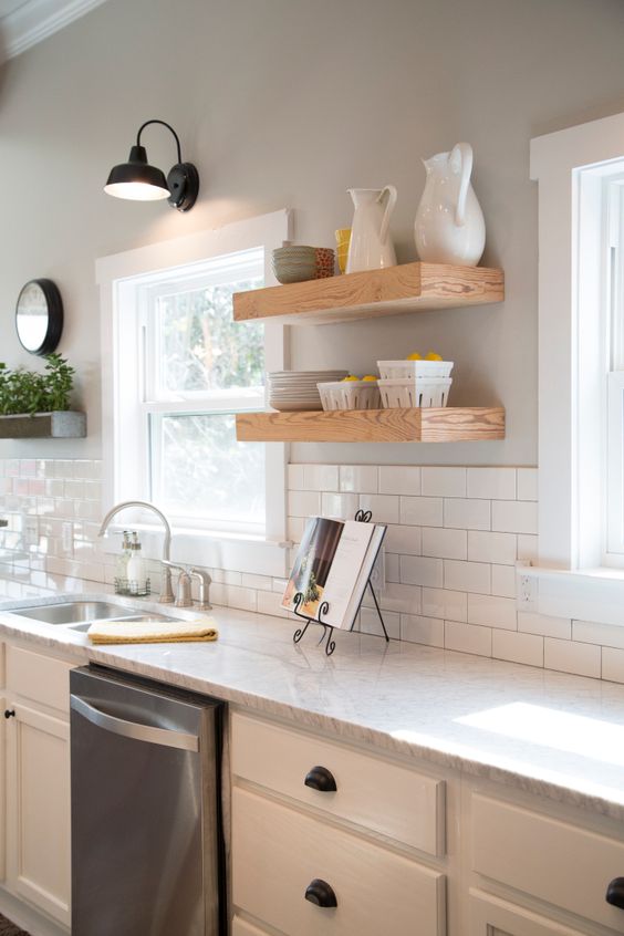 Fixer Upper Hosts Chip and Joanna Gaines have gutted and transformed the kitchen. They added new Carrera marble countertops, cabinets, floating wood shelves, a subway tile backsplash, and fresh light gray paint. Stainless appliances and a stainless sink and faucet are clean and modern, as seen on HGTV's Fixer Upper. (After 11a) Afters Fixer Upper Hosts Chip and Joanna Gaines have gutted and transformed the kitchen. They added new Carrera marble countertops, cabinets, floating wood shelves, a subway tile backsplash, and fresh light gray paint. Stainless appliances and a stainless sink and faucet are clean and modern, as seen on HGTV's Fixer Upper. (After 11a) Afters