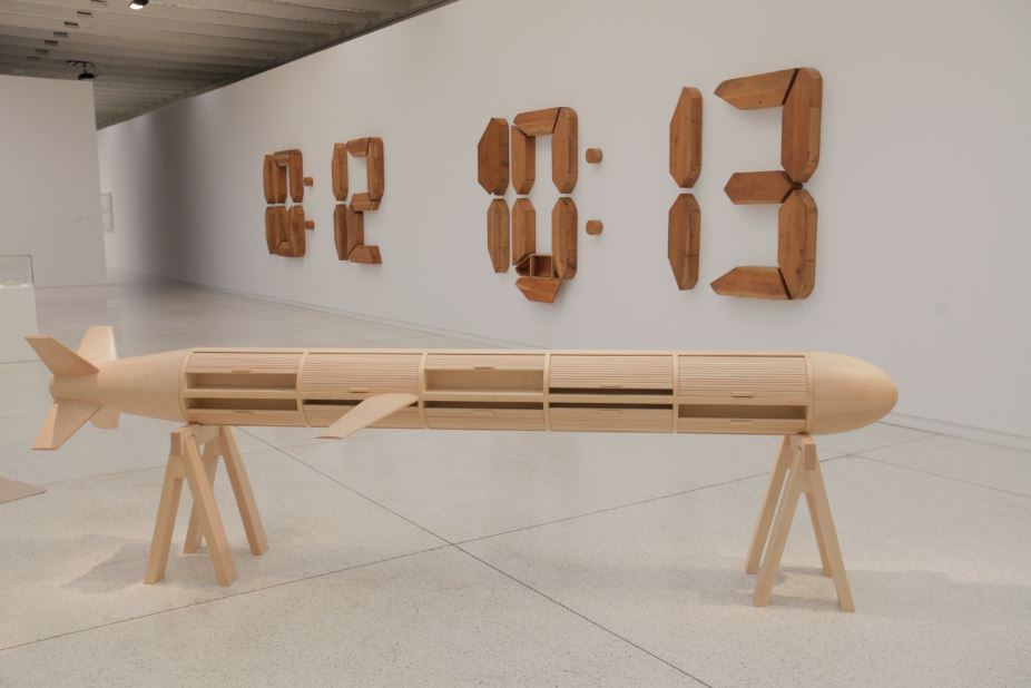 A obra "Un minuto", ao fundo, é meio arte, meio mobília. Cheia de portinhas, ela é composta por 34 peças soltas. A intenção é demonstrar quantas coisas cabem no intervalo de um minuto. Foto: Alison Martins/Gazeta do Povo