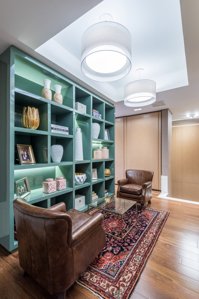 Estante em laca alto brilho verde é elemento vibrante no hall desse apartamento. Foto: Fernando Zequinão/Divulgação