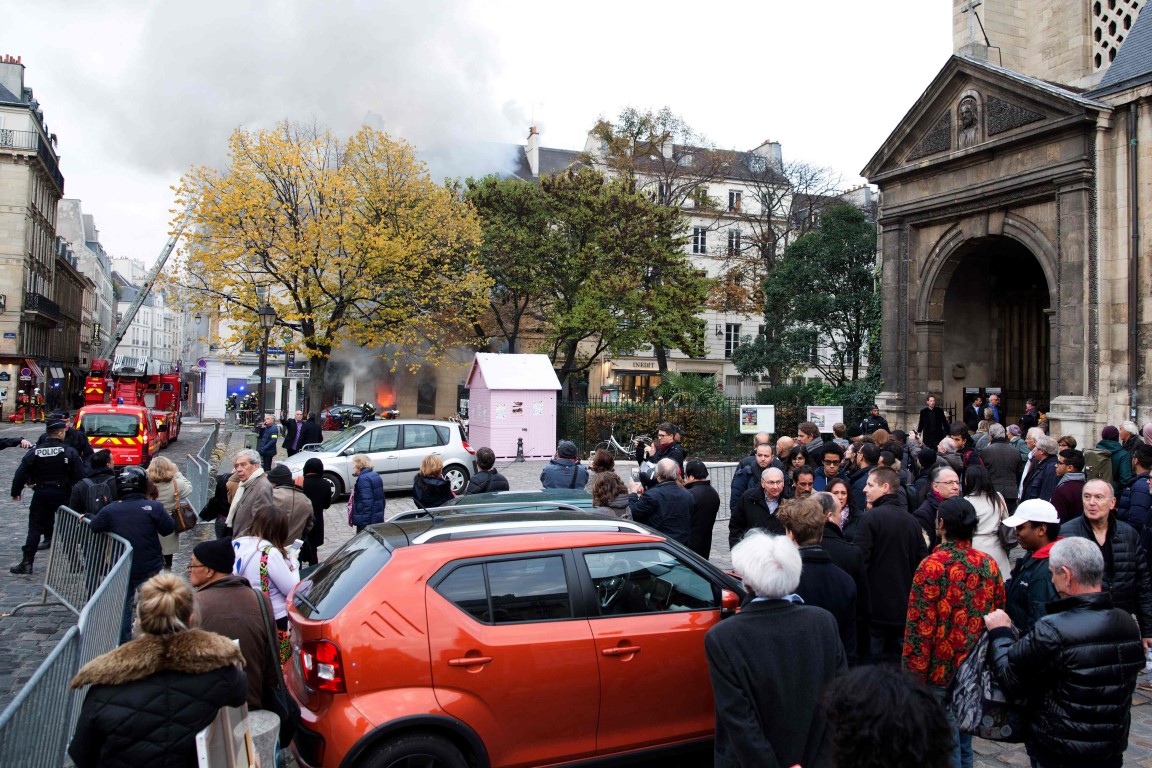 People watch as fire fighters work to put out a fire in "La Hune" book shop in the Saint-Germain-des-Pres district Paris on November 16, 2017.
Seven people were lightly injured in the fire, and some 50 firefighters and a dozen vehicles were deployed. / AFP PHOTO / Karim DAHER People watch as fire fighters work to put out a fire in "La Hune" book shop in the Saint-Germain-des-Pres district Paris on November 16, 2017.
Seven people were lightly injured in the fire, and some 50 firefighters and a dozen vehicles were deployed. / AFP PHOTO / Karim DAHER