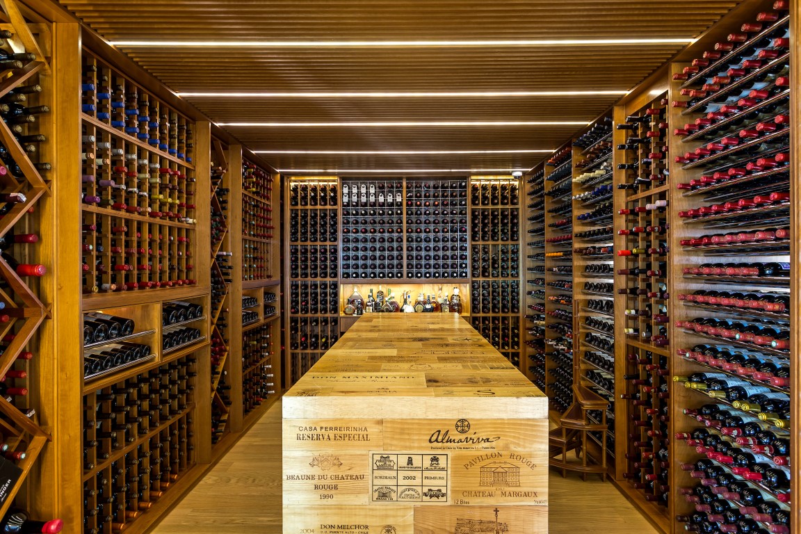 Espaço para mais de 1,3 mil garrafas fica entre o living e a sala de jantar, em projeto de um apartamento no Ecoville desenvolvido pela arquiteta Priscilla Müller. Foto: Eduardo Macarios/Divulgação