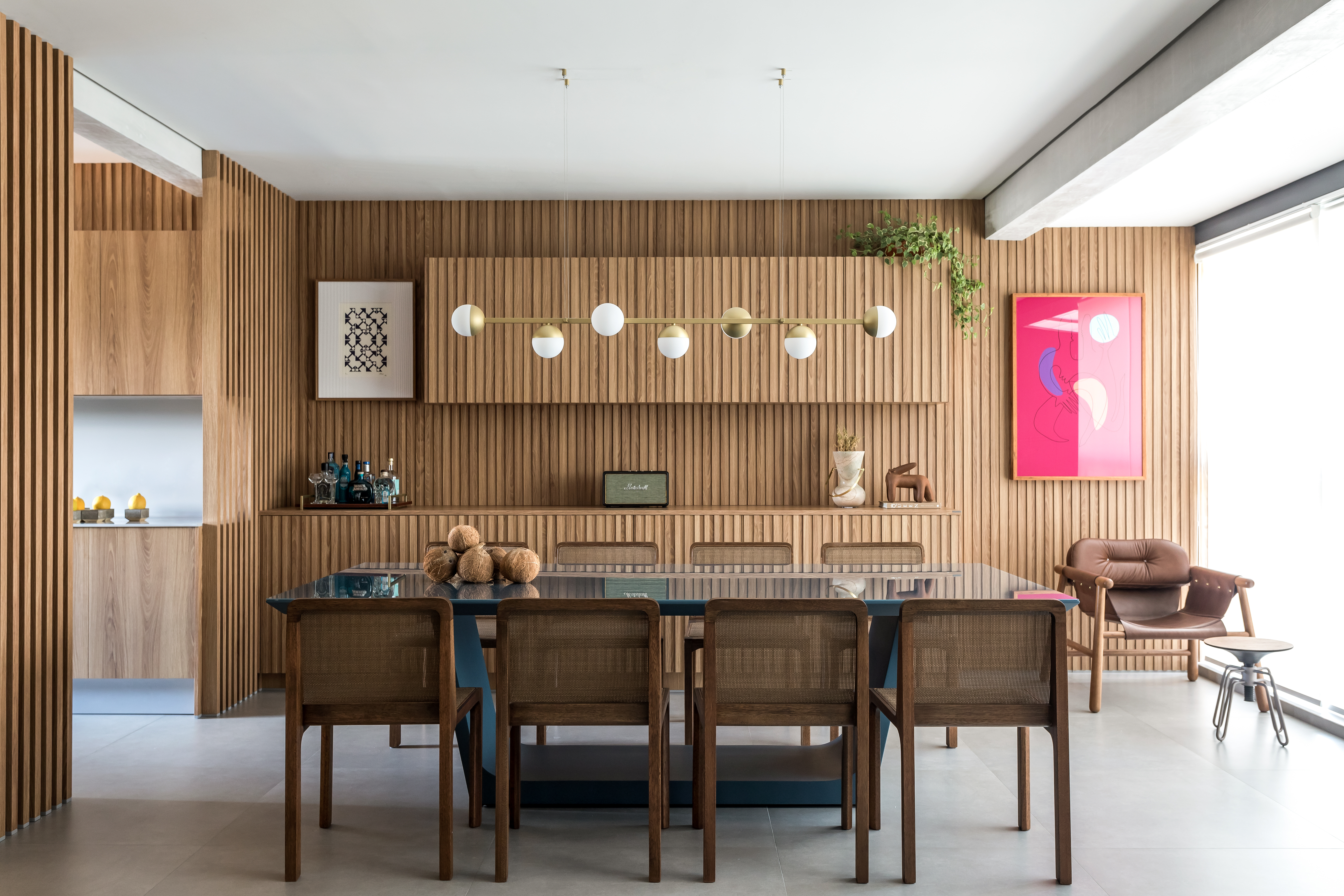 Na sala de jantar, a madeira ripada em louro-freijó se destaca no revestimento. Na sala de jantar, a madeira ripada em louro-freijó se destaca no revestimento.