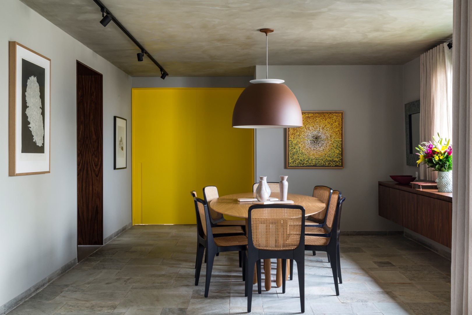 A porta que divide a sala de jantar e a cozinha é o grande destaque no espaço, fazendo contraste com o uso de materiais naturais, como pedra, madeira e linho. Projeto Luiz Paulo Andrade. Foto: Evelyn Muller / Divulgação A porta que divide a sala de jantar e a cozinha é o grande destaque no espaço, fazendo contraste com o uso de materiais naturais, como pedra, madeira e linho. Projeto Luiz Paulo Andrade. Foto: Evelyn Muller / Divulgação