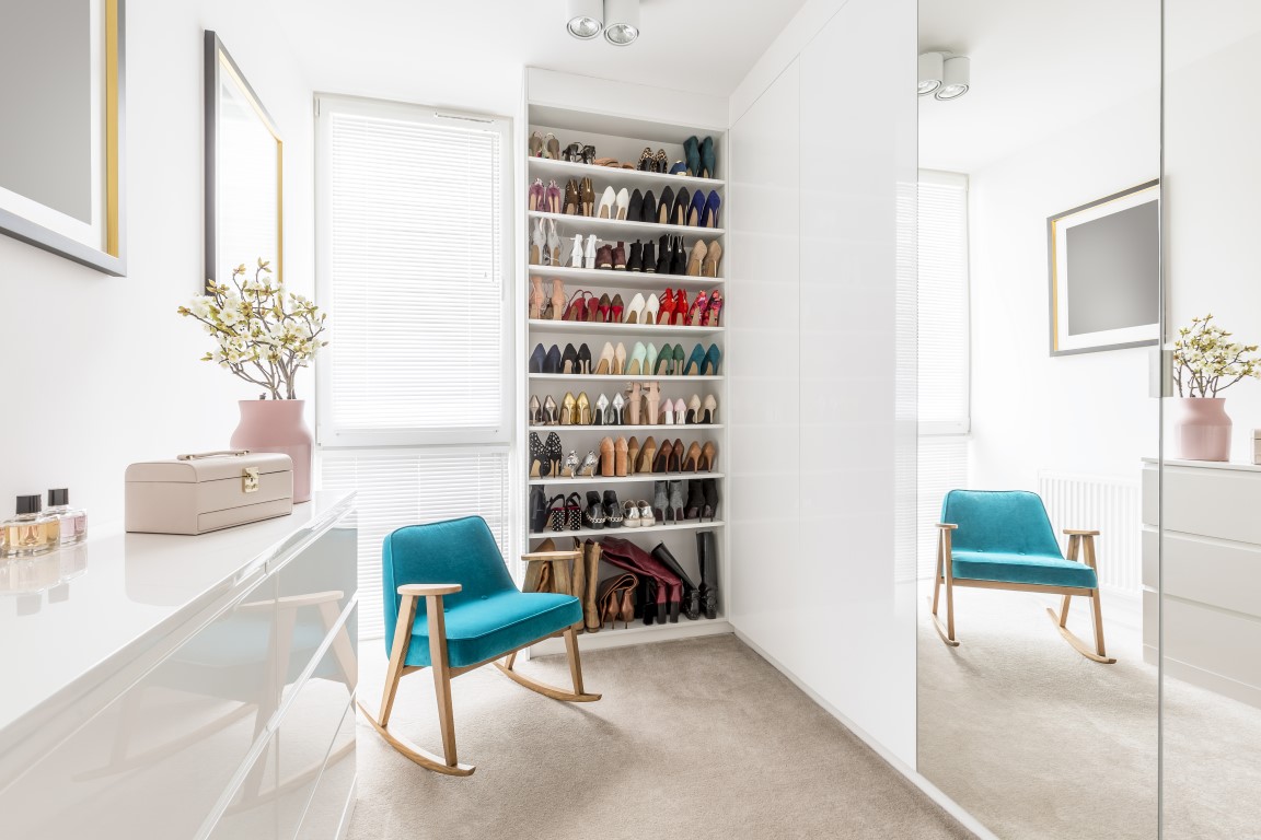 Dreamy feminine wardrobe with white furniture big mirror shoe closet beige carpet blue retro armchair and pastel pink accessories Dreamy feminine wardrobe with white furniture big mirror shoe closet beige carpet blue retro armchair and pastel pink accessories