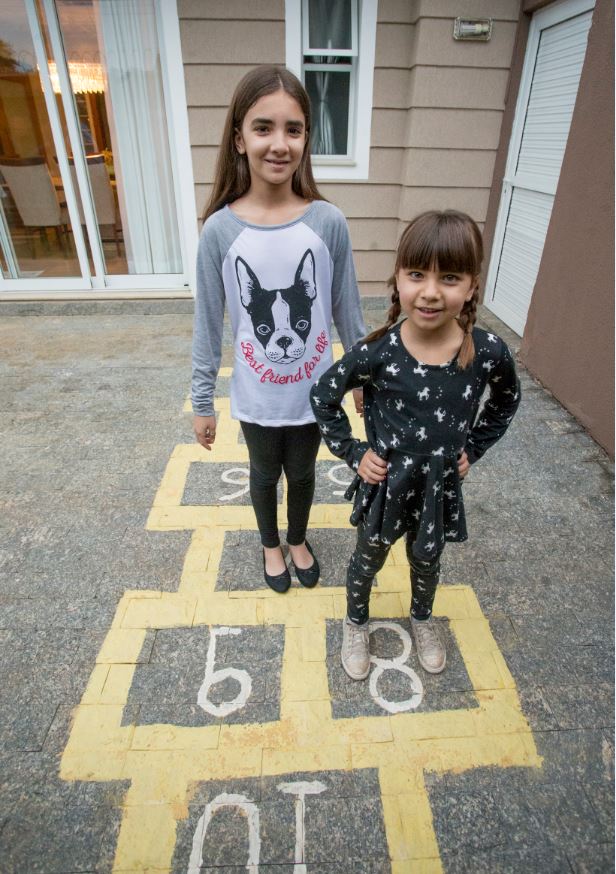 Helena, 9 anos, e Laís, 6, adoram brincar de amarelinha no quintal de casa. Foto: Hugo Harada/Gazeta do Povo Helena, 9 anos, e Laís, 6, adoram brincar de amarelinha no quintal de casa. Foto: Hugo Harada/Gazeta do Povo