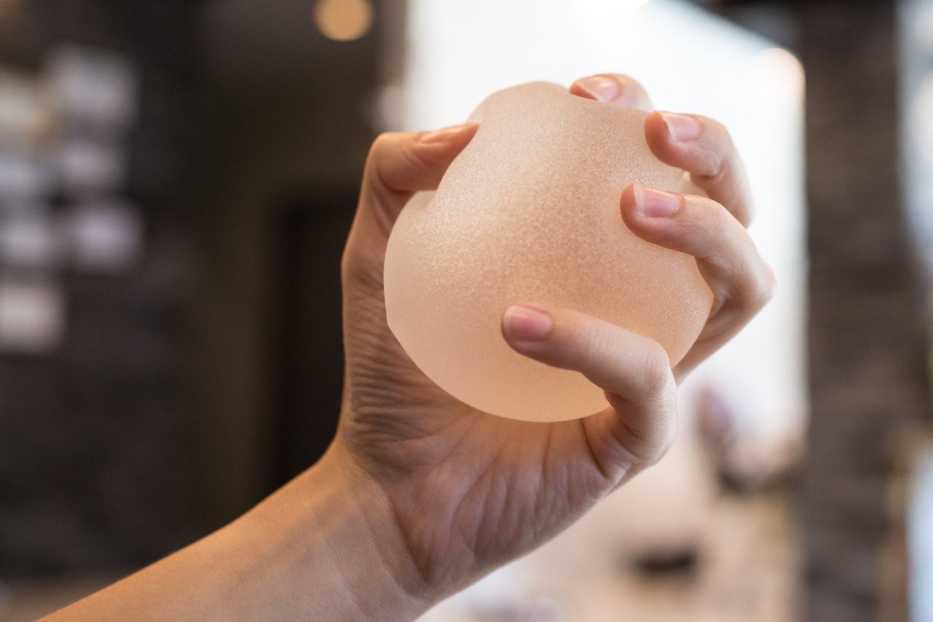 Close up Silicone breast implant on hands Close up Silicone breast implant on hands