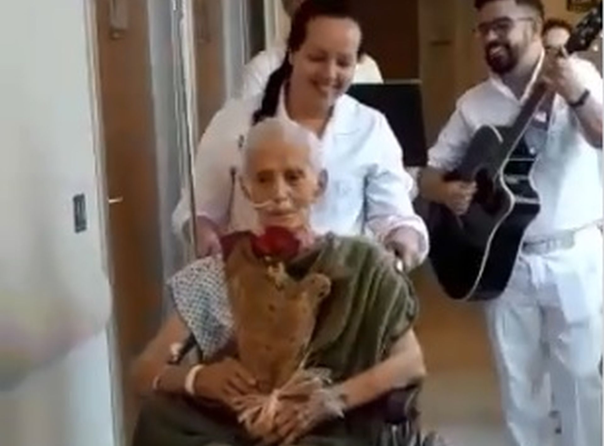 O idoso Antônio Onorino contou com a ajuda dos enfermeiros para entregar um buquê de rosas à sua esposa com fundo musical. Foto: Reprodução/Facebook