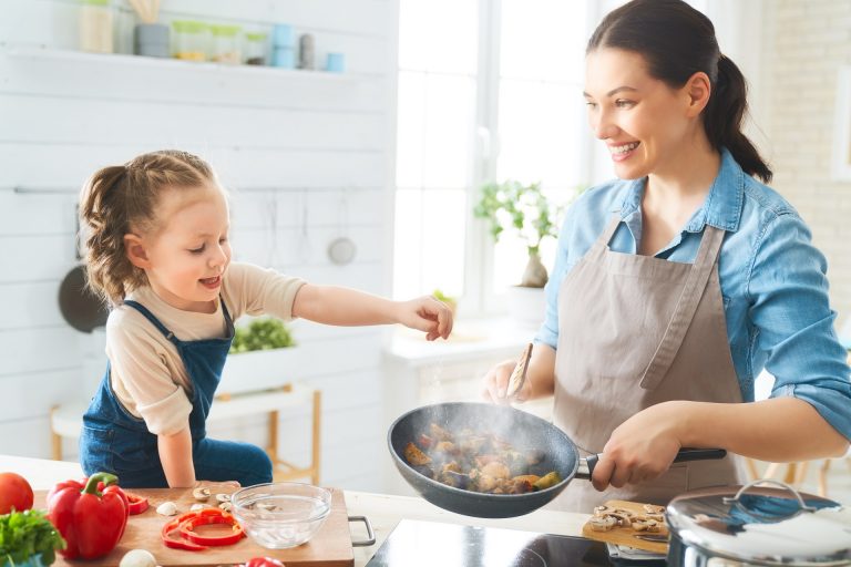 Healthy food at home. Happy family in the kitchen. Mother and child daughter are preparing proper meal.