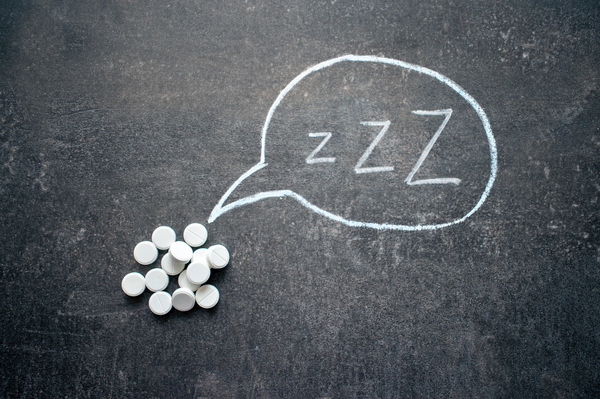 White pills in Z shape and text. Sleeping pills, hypnotic drugs, sedative, melatonin on dark night background White pills in Z shape and text. Sleeping pills, hypnotic drugs, sedative, melatonin on dark night background