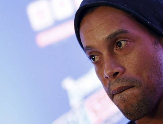 Brazilian soccer club Fluminense's player Ronaldinho listens during a news conference before starting a clinic with children in Mexico City