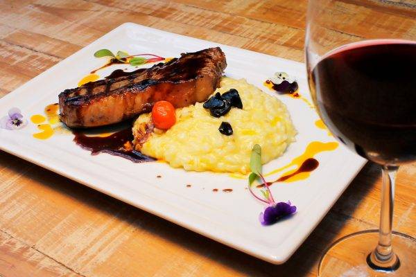 Bife de chorizo com molho demi glace, acompanhado de risoto com queijo gruyère e alho negro - a carne nobre no jantar harmonizado da Devons Steak House. (Fotos/ Black Flag Publicidade)