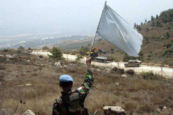 Membro da ONU acena uma bandeira da Força Interina das Nações Unidas no Líbano (UNIFIL) em 2010