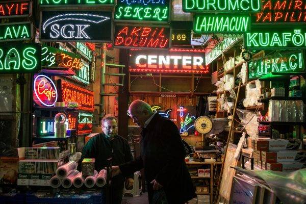 Homens conversam em comércio de lâmpadas led e de neon em Istambul (Bigstock)
