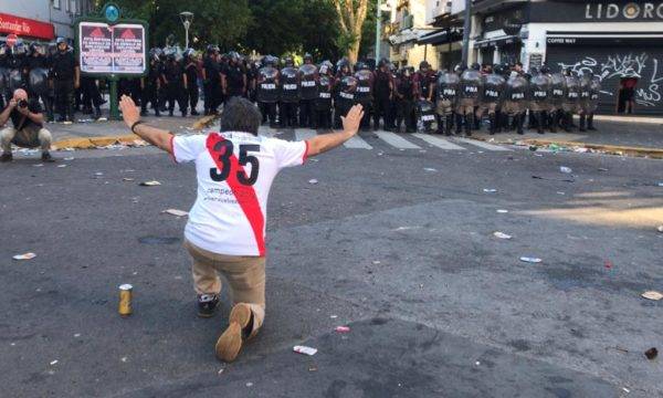 A guerra armada por Los Borrachos del Tablón e o impasse na final da Libertadores. Na imagem, torcedor do River e a polícia tardia. Fogo: Ivan PISARENKO / AFP
