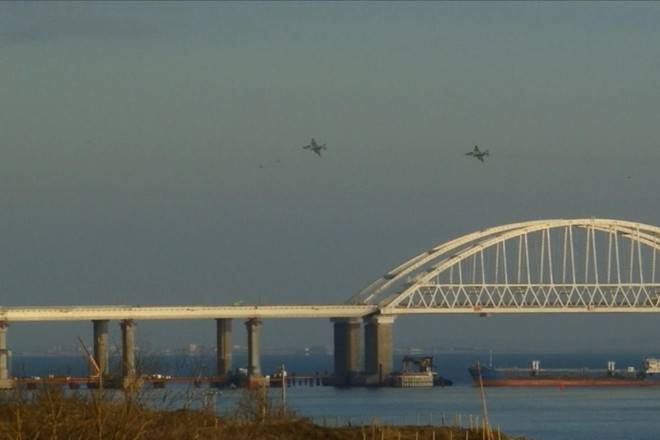 Barquinhos de papel e o controle do Mar Negro entre Ucrânia e Rússia Captura de tela de um vídeo transmitido pela mídia local mostra aviões russos sobrevoando a ponte da Crimeia sobre o Estreito de Kerch, que liga os mares Azov e Negro, enquanto um navio russo bloqueia o estreito, depois que a Rússia atacou e apreendeu três navios ucranianos em 25 de novembro
-AFP