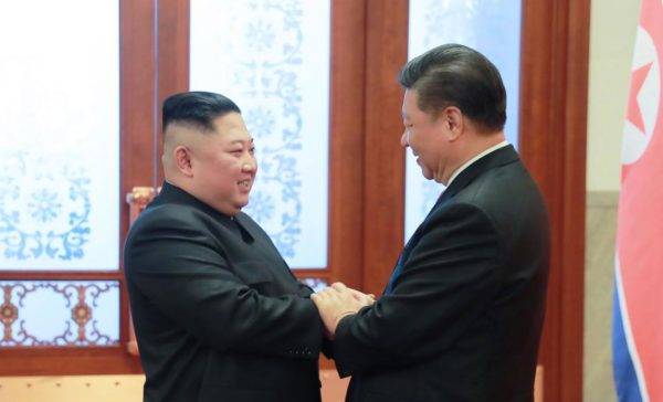 Ditador da Coreia do Norte, kim Jong-un, e presidente da China, Xi Jinping, se cumprimentam durante visita de Kim à China. FOTO: KCNA VIA KNS/AFP