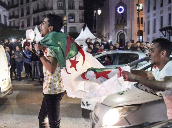 Manifestantes argelinos comemoram após o presidente Abdelaziz Bouteflika anunciar a retirada da sua candidatura a um quinto mandato. Foto: Ryad Kramdi / AFP