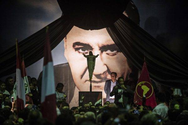 Supporters of late Peruvian former President Alan Garcia attend his wake as the coffin with the remains arrive to the American Popular Revolutionary Alliance (APRA) party headquarter's in Lima, on April 17, 2019. - Garcia, who was president from 1985-90 and again from 2006-11, died in hospital on April 17, 2019, after shooting himself in the head at his home as police were about to arrest him over the graft investigation. He was suspected of having taken bribes from Brazilian construction giant Odebrecht in return for large-scale public works contracts. (Photo by ERNESTO BENAVIDES / AFP)